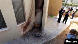 A policewoman looks at the damage after a rocket fired by Palestinian militants in Gaza landed in the southern town of Sderot on March 21.