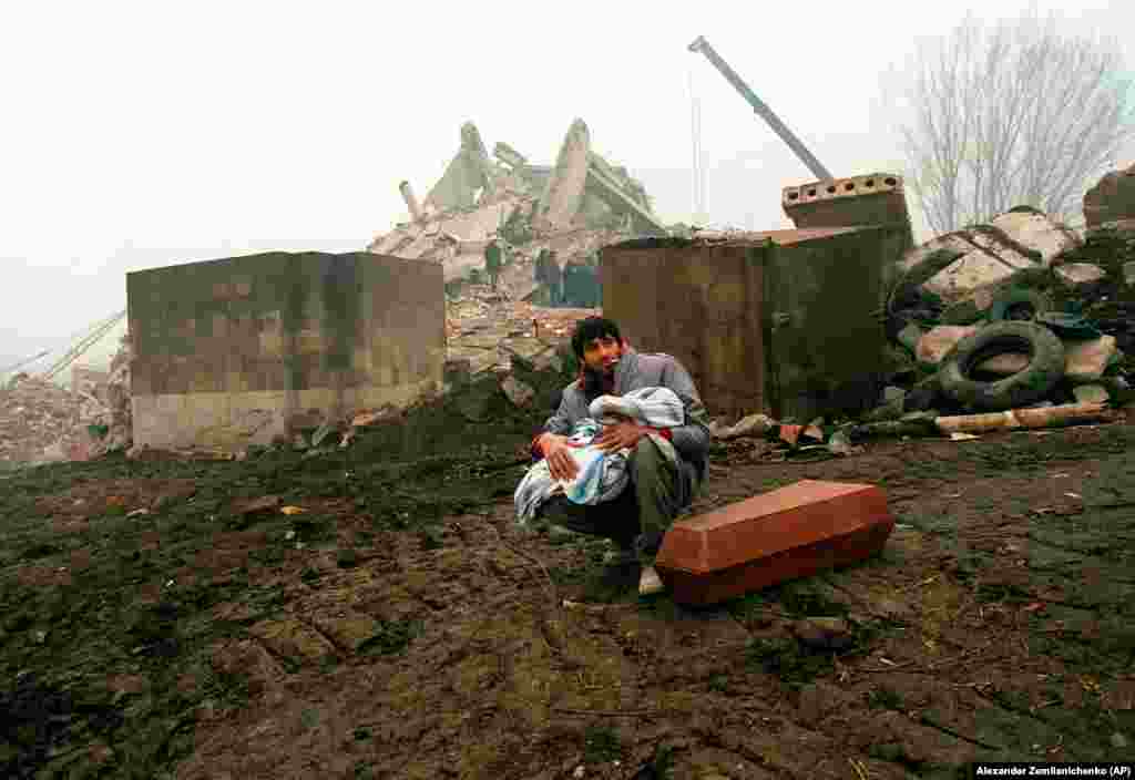 A man holds the body of his dead child in Gyumri. The quake lasted just 20 seconds, with a magnitude of 6.8, but the dust cleared to scenes of utter devastation. 