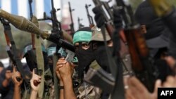 Membrii ai brigăzilor palestiniene Ezzedine al-Qassam serbează armistițiul drpt o victorie într-o tabără de refugiați din Fîșia Gaza