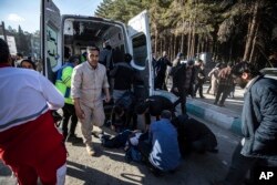 People take care of the injured after the explosions in Kerman, Iran, on January 3.