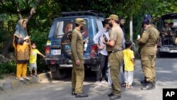 Police officers search a car at a temporary checkpoint around the home of Pakistani former Prime Minister Imran Khan in Lahore on May 17. 