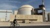 A worker rides a bicycle past the reactor building of the Bushehr nuclear power plant in Iran. (file photo)