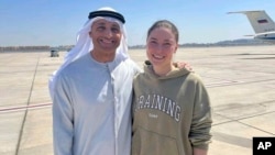 Ksenia Karelina (right) poses for a photo with UAE Ambassador to the US Yousef al-Otaiba following her release at an airport in Abu Dhabi on April 10. 