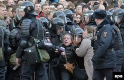 Russian riot policemen detain a demonstrator during an opposition rally organized by Navalny in central Moscow on March 26.