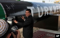 Öňki prezident Gurbanguly Berdimuhamedow gaz turbasyna gol çekýär. 2010 ý,