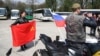 Расейскія байкеры пазуюць з расейскім ды савецкім сьцягамі ў Асьвенцыме.