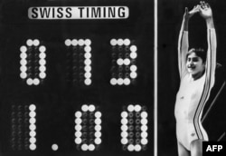 Romanian gymnast Nadia Comaneci celebrates a perfect 10 on the uneven bars at the Montreal Olympics in 1976. The score was so unprecedented that the scoreboard was unable to show it correctly.