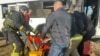 Ukrainian rescuers evacuate a wounded person from a bus damaged by a Russian drone strike in the town of Marhanets, in the Dnipropetrovsk region, on April 23.