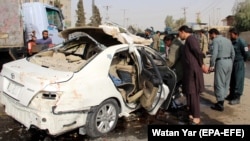 Afghan security officials inspect the scene of a IED blast in Helmand on November 12, 2020, that killed Radio Free Afghanistan journalist Mohammad Ilyas Dayee. 