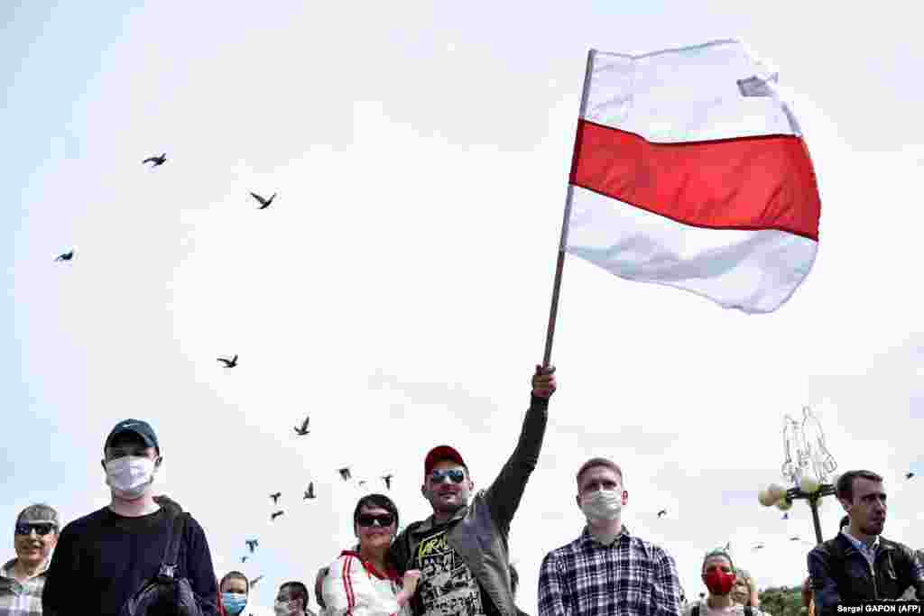 A protester waves the old Belarusian flag in Minsk during the collection of signatures. 