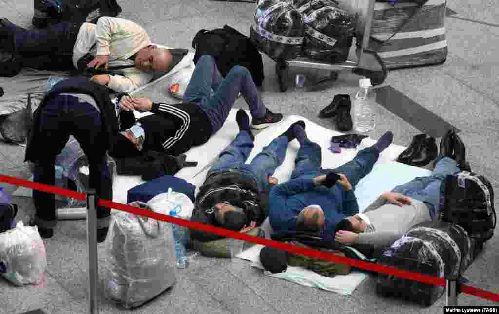Stranded travelers sleep on sheets at Vnukovo International Airport near Moscow on March 27, the first day the international flight ban ordered by the Russian government 
