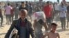 Palestinezët pasi kanë marrë ndihma humanitare të shpërndara nga GHF-ja në Rafah më 27 maj 2025. 