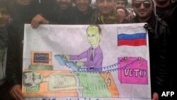 Syrians in the northwestern town of Kfar Nubul pose with a cartoon depicting Russia's Vladimir Putin defibrillating Syrian President Bashar al-Assad by using a veto to block a UN resolution against Assad.