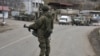 A Russian peacekeeper stands guard on a road in the town of Lachin in December 2020.