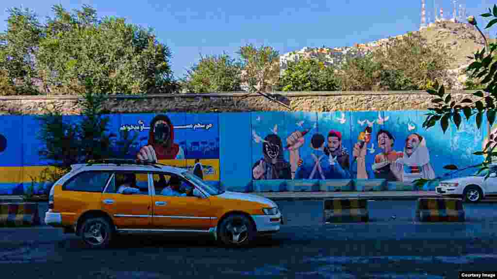 A mural promoting women's rights and a free press in Kabul with the females' faces blotted out. Some defacing of images such as this are believed to have been done by locals who support the Taliban and their worldview.