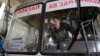 Водій розглядає осколкові отвори на лобовому склі автобуса, який був пошкоджений недалеко від Донецького аеропорту. Листопад 2014 року