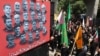 Persoanele îndoliate trec pe lângă un afiș cu portretele oamenilor de știință și comandanților militari uciși în timpul războiului de 12 zile dintre Iran și Israel, la Teheran, pe 5 iulie.