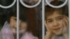 Воспитанники детского дома смотрят через окно. Иллюстративное фото.