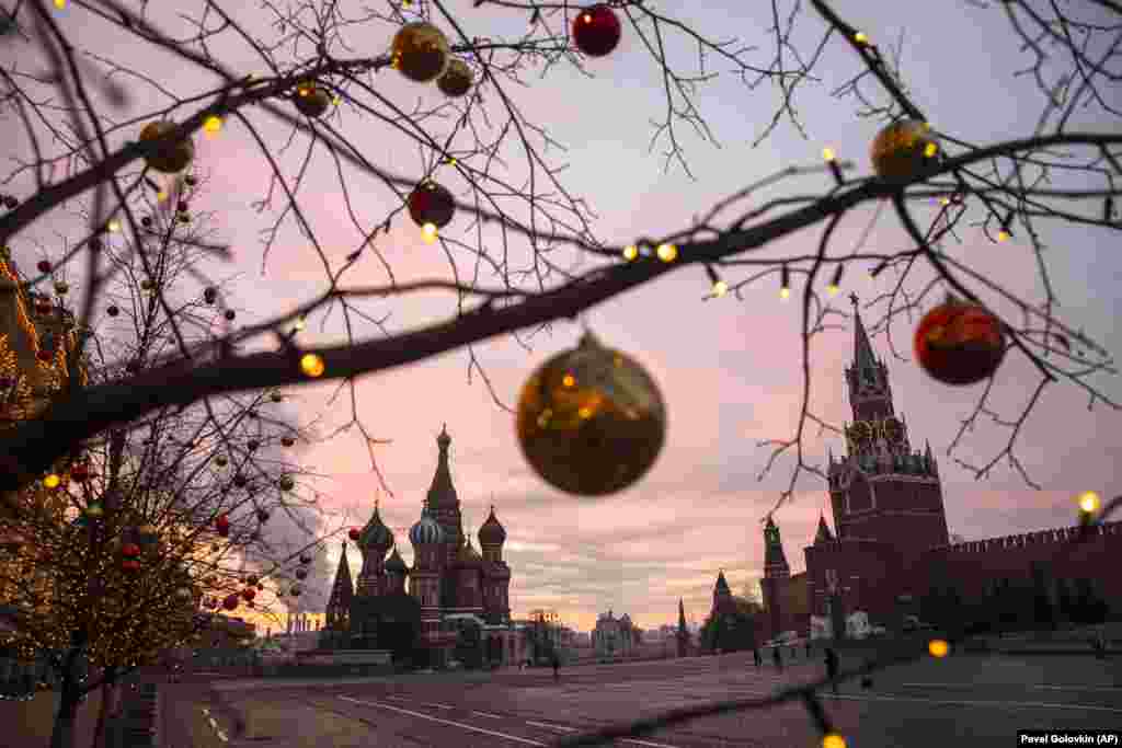 Ornaments hang from the trees as the sun rises over Moscow&#39;s Red Square on December 12. Mayor Sergei Sobyanin said there will be no massive New Year&#39;s celebrations in the city this year due to the COVID-19 pandemic.