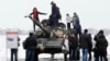 UKRAINE -- Local people pose on tank T-72 of the pro-Russian militant forces during celebration of Defender of the Fatherland Day at territory of former airport, in Luhansk, February 23, 2020