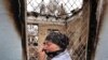 An ethnic Uzbek woman cries as she passes by a burned-out house in the town of Osh on June 24.