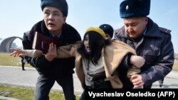 Милиционеры уводят участницу «Марша женской солидарности» в Бишкеке. 8 марта 2020 года.