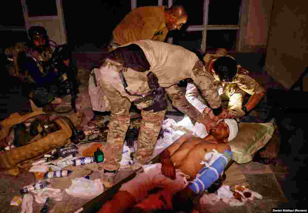 A special-forces soldier treats an Afghan National Army soldier who was injured in a firefight with the Taliban on June 12. 