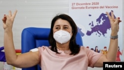 Лекарка от Неапол показва знака на победата, след като е ваксинирана с препарата на "Пфайзер" и "Бионтек"