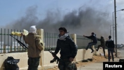 Rebels run after an air strike by pro-Qaddafi forces in the eastern city of Ras Lanouf on March 8.