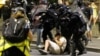 Srpski policajci privode demonstranta tokom obračuna između pristalica vladajuće stranke i antivladinih demonstranata u Beogradu, 13. avgusta 2025. godine.