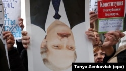 A protester holds a portrait of Belarusian President Alyaksandr Lukashenka upside down during a protest in Minsk.