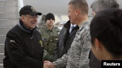 U.S. Defense Secretary Leon Panetta (left) is greeted by a serviceman as he arrives at the Manas Transit Center on March 13.