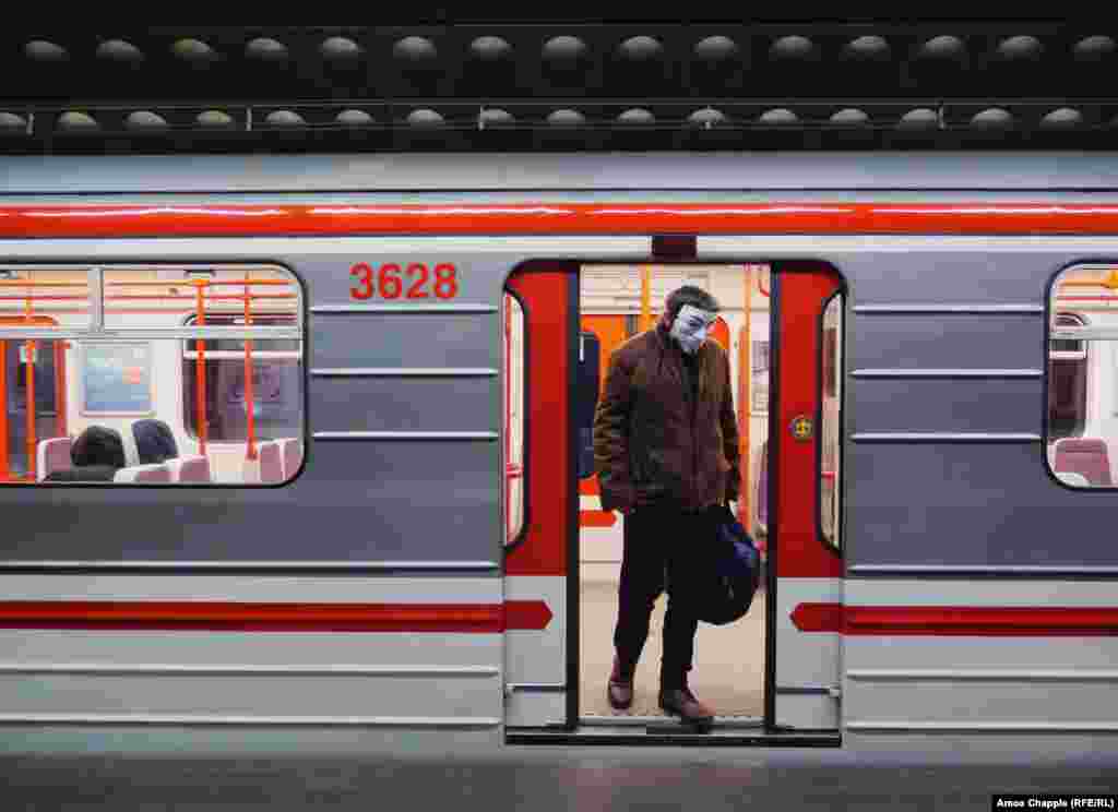 A man exits a subway car wearing a Guy Fawkes mask on March 17. The day before, Prague's mayor said on Twitter: “On Prague public transport, it is mandatory to have a covered mouth and nose! Whether you have medical masks, self-made masks, or use a scarf, anything is better than nothing.” 