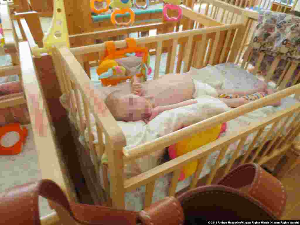 Sveta L., a 13-year-old girl in her crib in a "lying-down" room of an orphanage for children with disabilities in northwest Russia.