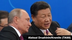 Russian President Vladimir Putin (L) and Chinese President Xi Jinping attend an ice hockey friendly game between junior teams in Tianjin on June 8.