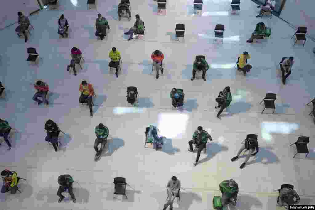 People wait for takeaway food orders at a shopping mall in Bangkok, Thailand, on March 24.