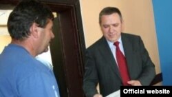 Ministar Goran Bogdanović uručuje ređenja o dodjeli podsticajnih sredstava u Kosovskoj Mitrovici, juni 2011 