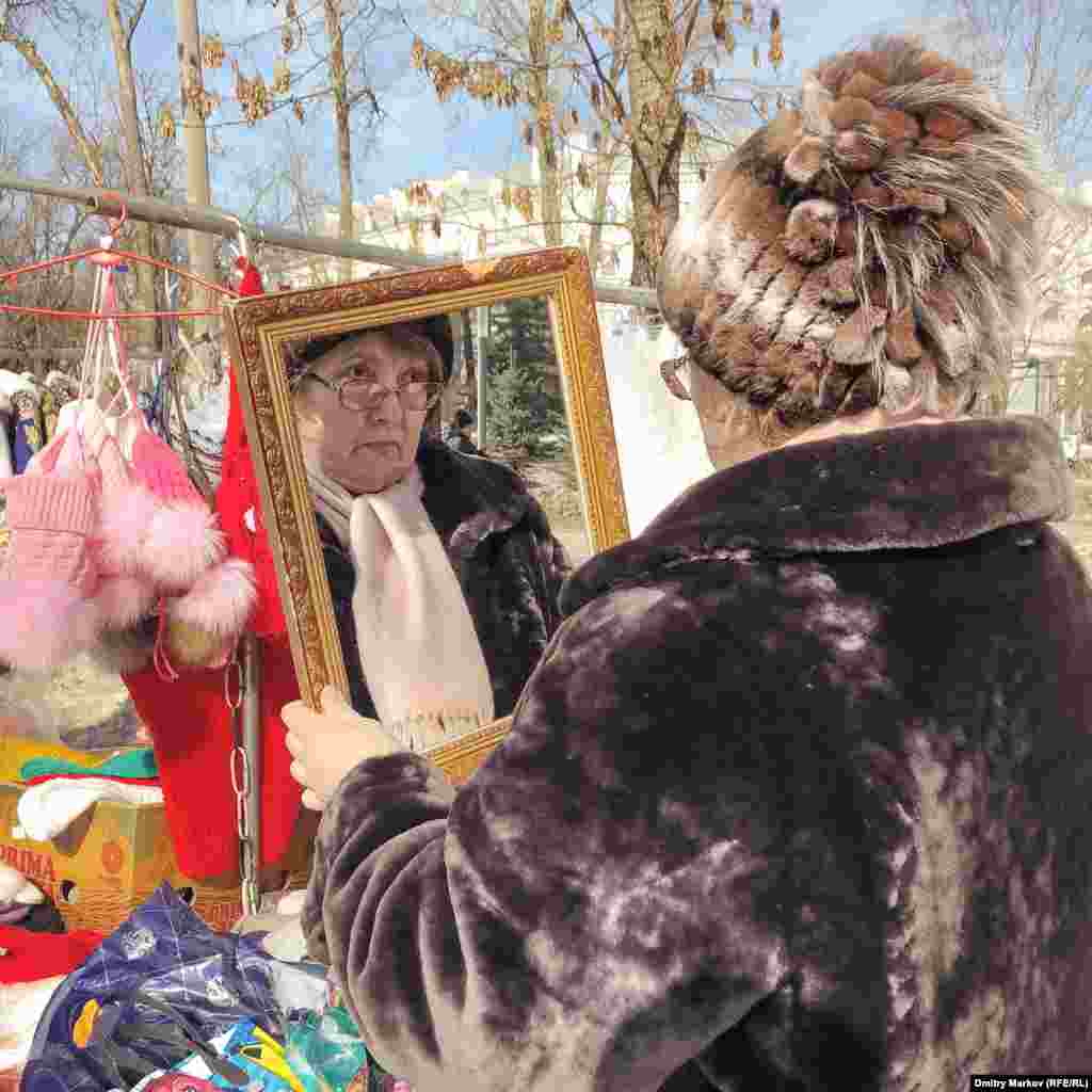 A customer tries on a hat at the fair. 