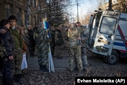 Relatives and members of a Ukrainian military medical unit comfort each other while mourning for four comrades killed near Debaltseve in February 2015.