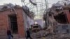 Local residents walk past what was reportedly damage from a missile strike in the Azerbaijani city of Ganca on October 8.