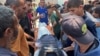 Trupul unuia dintre jurnaliștii uciși este purtat de palestinieni, la scurt timp după atacul asupra Spitalului din Nasser. 