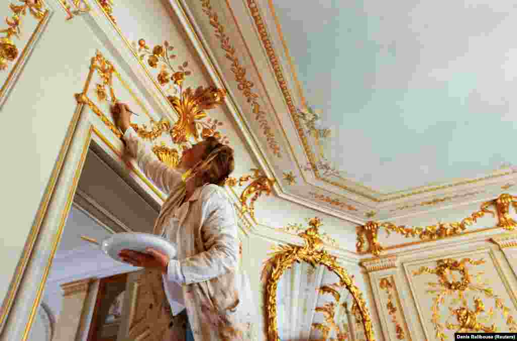 A painter touches up golden decoration inside the villa on June 11. 