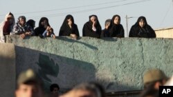 People watch an execution of a convicted man in the Iranian city of Qazvin in May