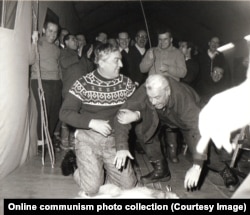 Romanian officials prepare to be beaten with a stick by Ceausescu as they crouch over a dead hare in 1969.