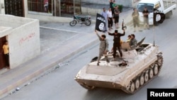 Militant Islamic State fighters take part in a military parade on the streets of the Syrian town of Raqqa, which was seized by the extremist group in August. (file photo)