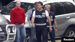 Police escort Anders Behring Breivik (in red) back to Utoeya Island on August 13 to reenact his alleged rampage at a youth camp.