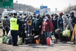 Many Ukrainian migrants line up to go home after the announcement that the Polish-Ukrainian border crossing at Dorohusk was to be closed following a coronavirus outbreak in March..