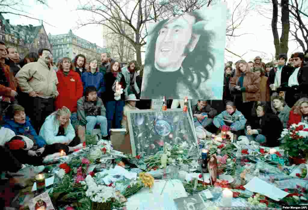 Un mare grup de fani se adună în Strawberry Fields din Central Park din New York, 8 decembrie 1990, pentru comemorarea a zece ani de la moartea lui John Lennon. În fundal se află clădirea de apartamente Dakota, unde au locuit Lennon și soția.