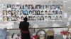 Russia -- A woman stands near children's pictures in the destroyed school sport hall in Beslan, 30May2007