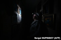 A man wears a headlamp during a power cut in his building in the north of Kyiv.